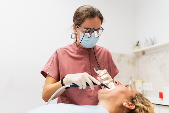 Dentist performing dental examination on patient in clinic