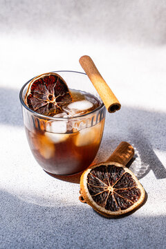 Spiced iced coffee with cinnamon and dried orange slice