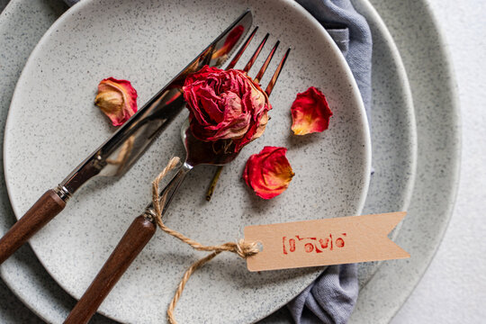 Dried red rose petals with love tag on plate