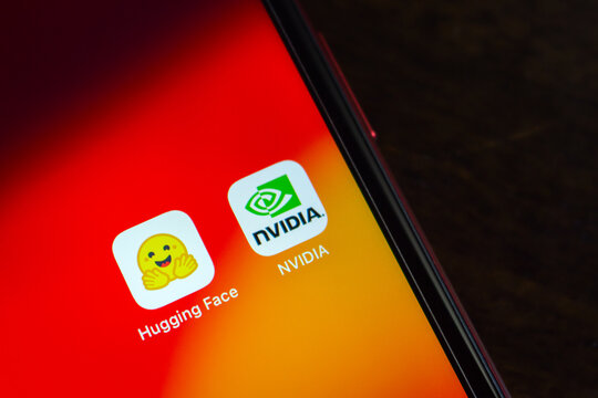 Quetzaltenango, GUATEMALA - Sep 9 2026 : Close-up of a smartphone home screen showing the Hugging Face and NVIDIA app icons side by side on a red and orange gradient wallpaper.