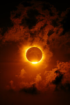 Dramatic solar eclipse with fiery corona and dark cloud