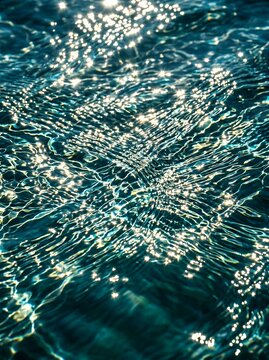 Sparkling Sunlight Reflecting on Rippling Blue Water Surface.