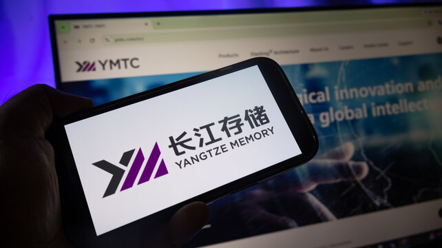 Yangtze Memory brand logo shown on mobile device screen near monitor.