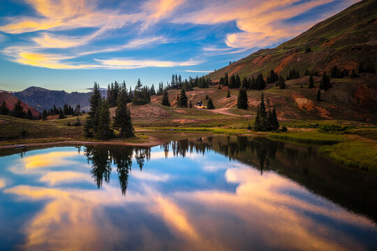 Stunning sunset reflection in an alpine lake with an off road vehicle