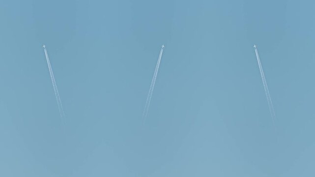 Commercial passenger airplanes cruising at high altitude on blue sky , view from a distance