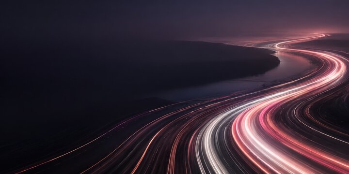 Long Exposure Light Trails of Night Traffic Sweeping Along Curving Highway Through Dark Landscape for Transportation and High Speed Mobility Concept