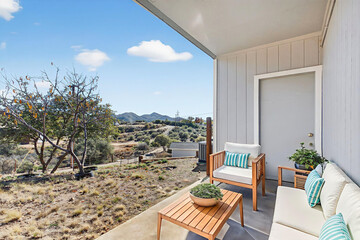 Obraz premium Cozy balcony seating with hillside view and sunny terrace