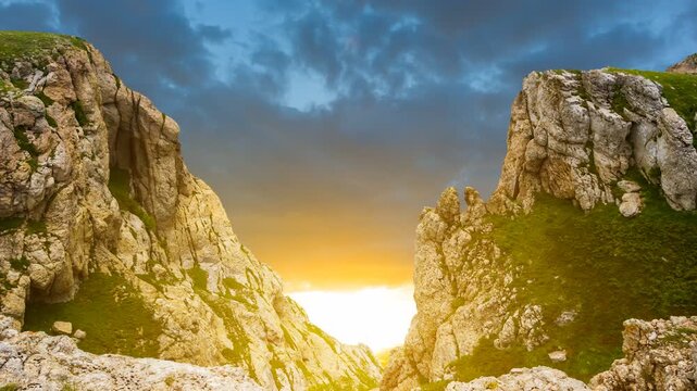 view to a sunset from a crack in the mountain time lapse scene