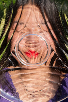 abstract distorted portrait of asian woman behind glass plate