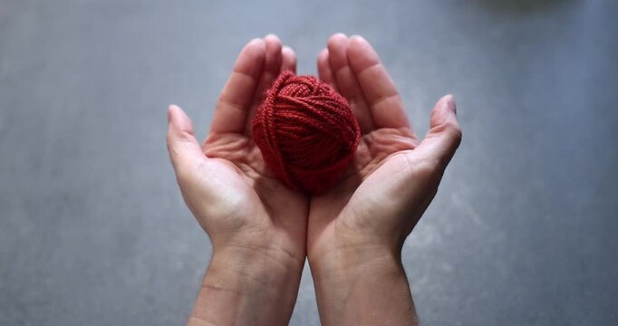 Hands holding red yarn and a crochet hook, crafting detail. hands, 
