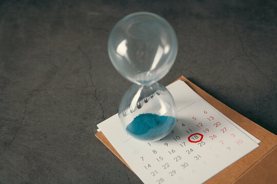 Hourglass and calendar on black background. Time management and planning concept