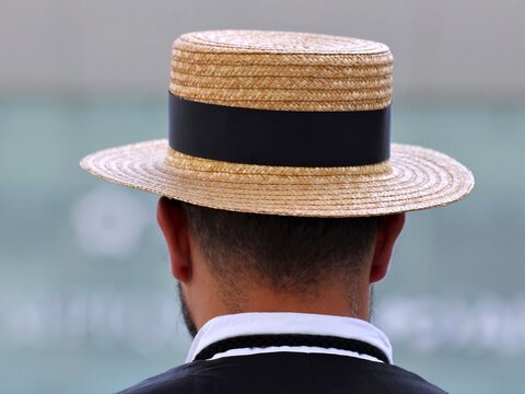 Vue arri&egrave;re en gros plan d'un homme barbu &eacute;l&eacute;gant portant un chapeau de paille avec un fond gris en arri&egrave;re plan