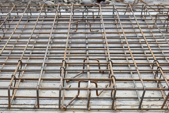 Steel rebar reinforcement grid prepared for concrete pouring at an urban road reconstruction site

