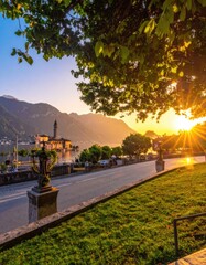 Obraz premium Serene Lakeside Town at Sunset with Mountain Backdrop