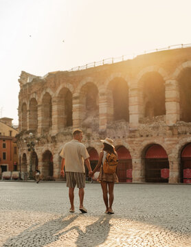 Couple enjoying a romantic stroll near the historic arena in Verona, Italy at sunset