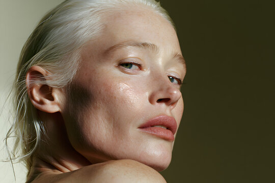 Close-up beauty portrait of woman with silver hair and dewy skin