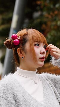 Young Japanese Woman with Harajuku Fashion Adjusting Hair in Tokyo