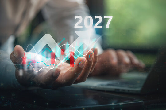 Year 2027 Business Forecasting Concept with Cupped Hand Holding Stock Market Growth Chart.
