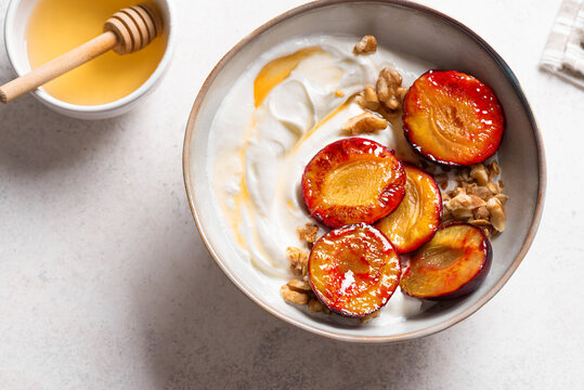 Roasted plums with yogurt, honey and nuts
