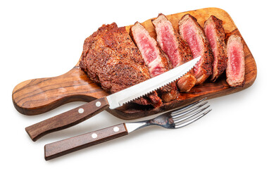 Sliced grilled beef ribeye steak on olive wooden board with knife and fork isolated on a white...