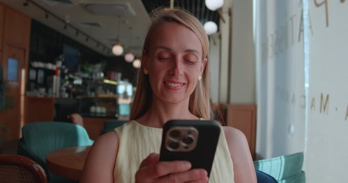 Smiling Woman Using Smartphone in Modern Cafe in Tashkent Uzbekistan