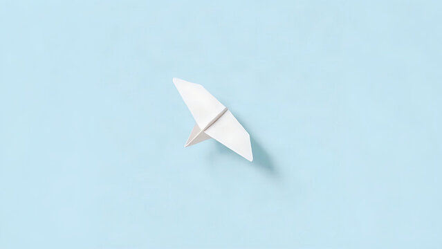 A simple white paper airplane against a soft blue background, minimalist aesthetic.