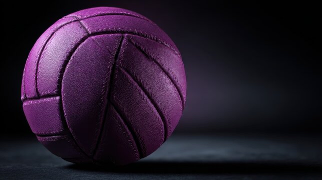 Purple basketball on dark background, textured basketball in dramatic studio light, sports equipment photo