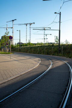 Tram tracks curve through an urban transport and mobility corridor in Nordbahnviertel Vienna Austria with construction cranes marking ongoing district development