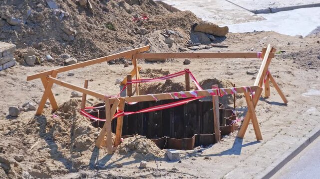Roadworks Construction Site Overpass Pillar Foundation Excavation Pit Secured with Metal Wall Wooden Barrier and Safety Tape