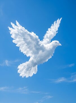 White dove made of clouds flying in a clear blue sky.