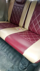 Obraz premium Custom car seat upholstery in a luxurious diamond stitch pattern, featuring a rich maroon and cream leatherette. This image highlights automotive interior design, craftsmanship.