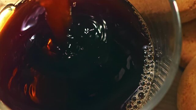 Coffee is poured into a transparent cup from a top-down perspective at 1000 fps, revealing rich crema, swirling movement and delicate splashes in a refined cinematic close-up.