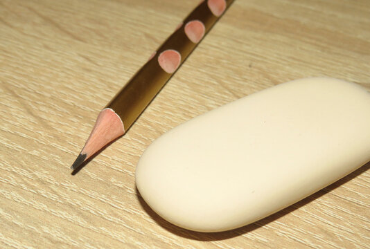 Pencil and an eraser on a wooden background