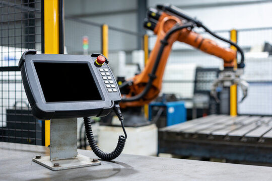 Robot teaching pendant controller with industrial arm in workshop