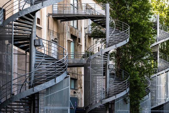 Spiral staircase and layered architecture create abstract urban facade geometry with metal structure and exterior design details