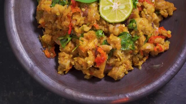 Tilt down view of traditional Indonesian sambal tempe in a mortar