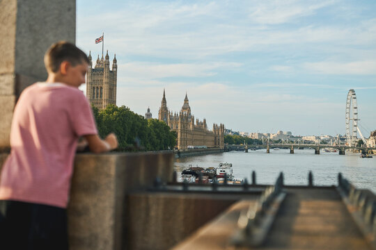 Boy overlooking Westminster and London Eye across the Thames