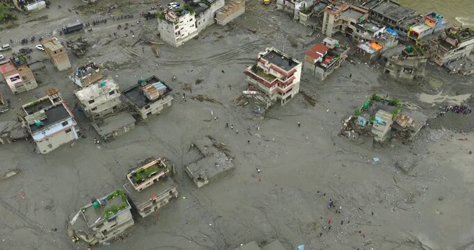 Rasuwa, Nepal, drone glide shot of destroyed houses and vehicles buried under thick mud and silt after a catastrophic Tibetan glacial flood on August 26