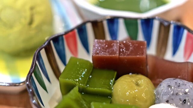 Matcha green tea ice cream served with assorted Japanese-style sweets, creating an elegant dessert presentation with authentic Asian flavors and textures.