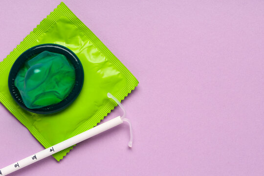 Contraception and family planning, green condom and intrauterine device iud for birth control and reproductive health on a purple background