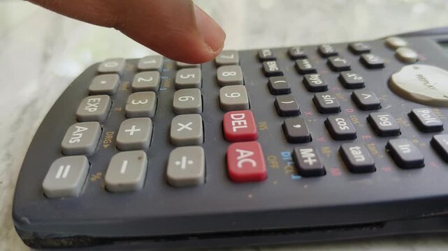 Close up of person finger click numbers buttons on calculator keypad for calculating budget, taxes or business expense. Financial accounting or calculation concept.