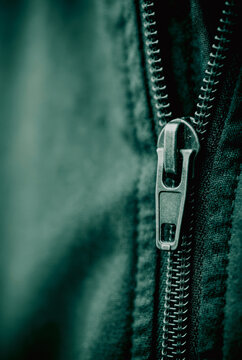 Close up of a metal zipper on a dark fabric jacket