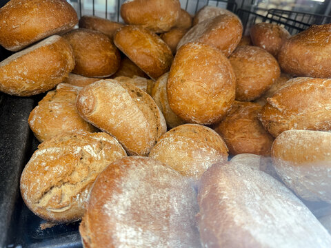 Freshly baked bread rolls piled in bakery display