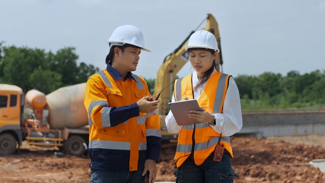 Construction Engineers Reviewing Digital Plans at Infrastructure Work Site