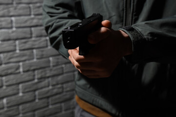 Obraz premium Crime and violence prevention, person holding a handgun in a dark urban environment for security threat or law enforcement training and safety
