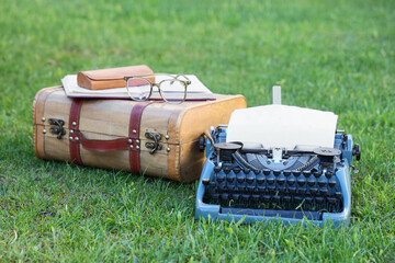 Creative writing and storytelling concept, vintage typewriter with old suitcase and glasses on...