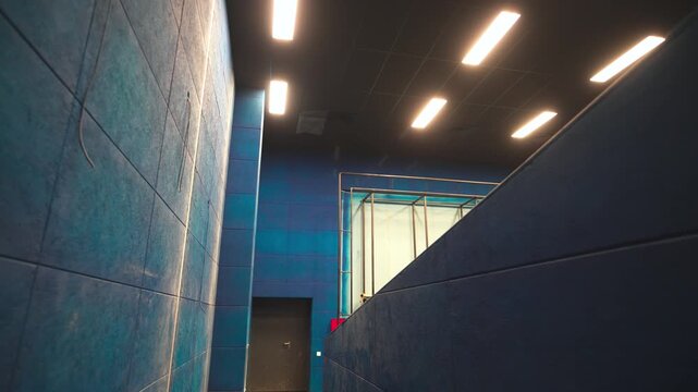 Stylish cinema hall corridor leading to screen frame at amusement center. Incomplete entertainment complex broadcasting movies for guests