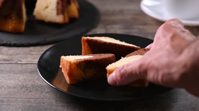 Hand taking a slice of chocolate marble cake