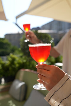 People Toasting with Red Cocktails on Outdoor Summer Terrace
