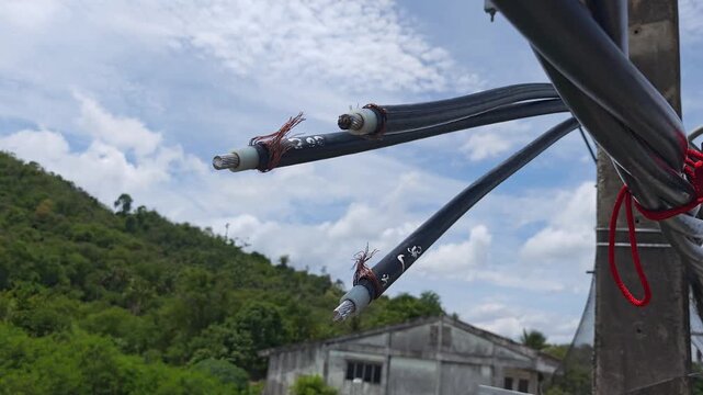 Pan right video of stripped twisted aerial cables prepared for jointing process showing copper shield and aluminum conductor, industrial electrical power grid infrastructure.